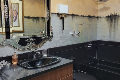 Inredning av ett klassiskt mellanstort svart svart badrum, med släta luckor, skåp i mellenmörkt trä, ett platsbyggt badkar, svart kakel, keramikplattor, klinkergolv i porslin, ett nedsänkt handfat, laminatbänkskiva och svart golv