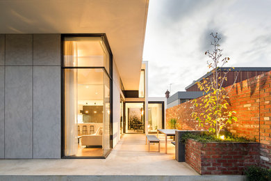 Photo of a contemporary two-storey exterior in Melbourne with stone veneer.