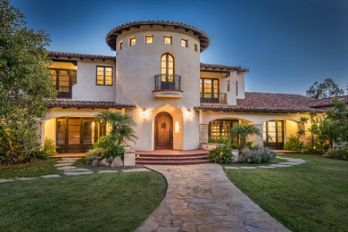 Inspiration for an expansive mediterranean two-storey beige exterior in Los Angeles with a gable roof.