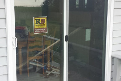 This is an example of a mid-sized mudroom in Baltimore with a sliding front door and a white front door.