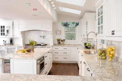 Inspiration for a large transitional u-shaped dark wood floor and brown floor eat-in kitchen remodel in Boston with an undermount sink, raised-panel cabinets, white cabinets, granite countertops, white backsplash, ceramic backsplash, stainless steel appliances, an island and multicolored countertops