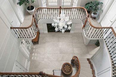This is an example of a large transitional foyer in Toronto with a double front door, white walls, travertine floors, a dark wood front door and beige floor.