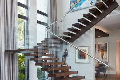 Contemporary wood u-shaped staircase in Miami with open risers and glass railing.