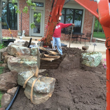 Setting retaining wall rocks.