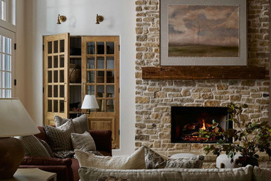 Living room - country exposed beam living room idea in Oklahoma City with white walls, a standard fireplace and a stone fireplace
