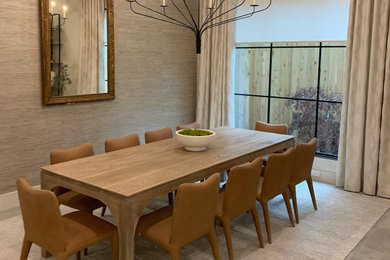 Cette image montre une grande salle à manger ouverte sur la cuisine minimaliste avec un mur beige, moquette et un sol gris.