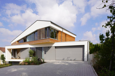 Cette image montre une façade de maison blanche design en pierre de taille moyenne et à un étage avec un toit à deux pans.