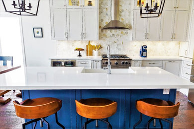 Large cottage l-shaped medium tone wood floor and brown floor eat-in kitchen photo in Other with a farmhouse sink, recessed-panel cabinets, white cabinets, quartzite countertops, white backsplash, marble backsplash, stainless steel appliances, an island and white countertops
