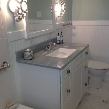 Solid surface serenity colored countertop with a white bowl and white cabinets a