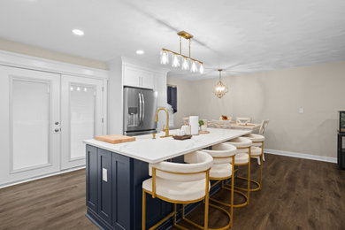 Inspiration for a mid-sized modern l-shaped laminate floor and brown floor eat-in kitchen remodel in Other with a farmhouse sink, shaker cabinets, blue cabinets, quartzite countertops, white backsplash, porcelain backsplash, stainless steel appliances, an island and white countertops