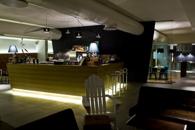 Idee per un grande bancone bar minimalista con ante in legno chiaro, top in acciaio inossidabile e pavimento grigio