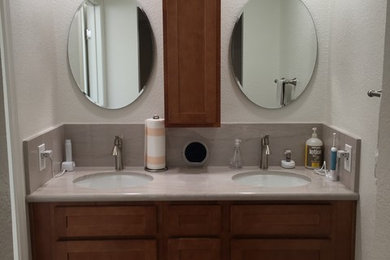 Small transitional master bathroom in Orange County with shaker cabinets, medium wood cabinets, an open shower, a one-piece toilet, white tile, ceramic tile, white walls, porcelain floors, an undermount sink, quartzite benchtops, brown floor, a hinged shower door and beige benchtops.