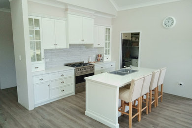 Kitchen in Other with white cabinets, quartz benchtops, with island and white benchtop.