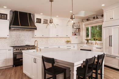 Inspiration for a large timeless u-shaped light wood floor eat-in kitchen remodel in Seattle with a farmhouse sink, shaker cabinets, white cabinets, quartz countertops, white backsplash, marble backsplash, black appliances, an island and white countertops