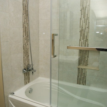 Acrylic bathtub with tile surround and glass enclosure