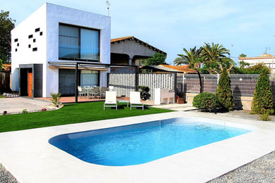 Ejemplo de piscina natural mediterránea pequeña a medida en patio