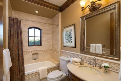 Elegant beige tile bathroom photo in Austin with furniture-like cabinets, dark wood cabinets, a two-piece toilet, beige walls, an undermount sink and granite countertops