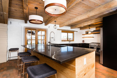 Enclosed kitchen - mid-sized rustic brick floor and red floor enclosed kitchen idea in Albuquerque with quartz countertops, white backsplash, porcelain backsplash, stainless steel appliances, an island and multicolored countertops