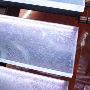 Glass private bar and glass stair treads inside a man cave in Michigan