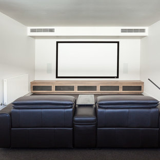 This is an example of a medium sized contemporary enclosed home cinema in Melbourne with white walls, carpet, a projector screen and grey floors.