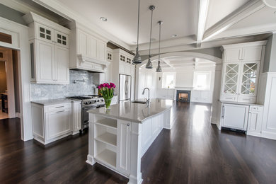Example of a large classic u-shaped dark wood floor eat-in kitchen design in Portland with a drop-in sink, raised-panel cabinets, white cabinets, soapstone countertops, white backsplash, marble backsplash, stainless steel appliances and an island
