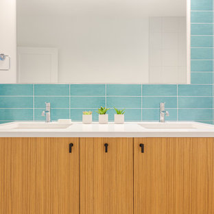 Ispirazione per una piccola stanza da bagno per bambini moderna con ante lisce, ante in legno chiaro, vasca da incasso, vasca/doccia, WC monopezzo, piastrelle blu, piastrelle in ceramica, pareti bianche, pavimento con piastrelle in ceramica, lavabo sottopiano, top in quarzo composito, pavimento bianco e doccia con tenda