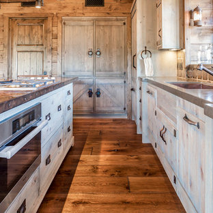 Inspiration pour une arrière-cuisine chalet en L de taille moyenne avec un évier 1 bac, un placard à porte plane, des portes de placard beiges, un plan de travail en cuivre, une crédence multicolore, une crédence en carreau de porcelaine, un électroménager en acier inoxydable, un sol en bois brun et un îlot central.