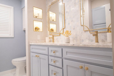Inspiration for a transitional 3/4 blue tile and marble tile porcelain tile, white floor and double-sink tub/shower combo remodel in Dallas with shaker cabinets, blue cabinets, gray walls, an undermount sink, marble countertops, white countertops and a built-in vanity
