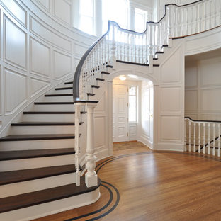 ニューアークの大きい木のトラディショナルスタイルのおしゃれなサーキュラー階段 (フローリングの蹴込み板) の写真