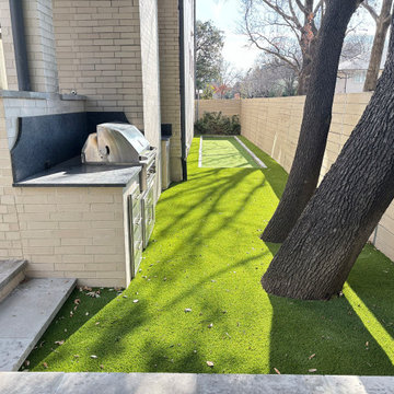 Built-In Outdoor Kitchen With Stainless Grill and Turf Side Yard