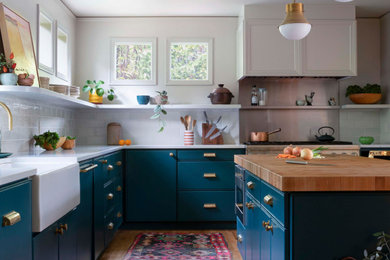 Eat-in kitchen - mid-sized 1950s light wood floor and beige floor eat-in kitchen idea in Portland with a farmhouse sink, beaded inset cabinets, blue cabinets, quartzite countertops, green backsplash, ceramic backsplash, stainless steel appliances, an island and white countertops