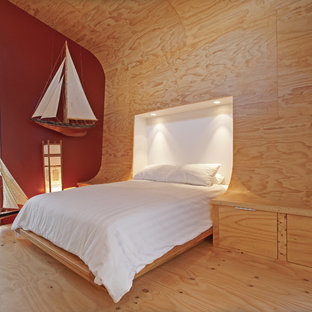 Modern inredning av ett litet sovloft, med flerfärgade väggar och plywoodgolv