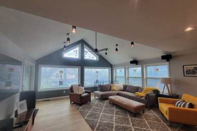Modelo de sala de estar tipo loft actual grande con suelo laminado, suelo marrón y machihembrado