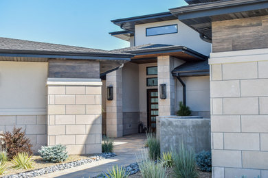 Inspiration for a modern beige stone house exterior remodel in Other with a shingle roof and a black roof