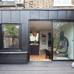 Пример оригинального дизайна интерьера: фасад таунхауса среднего размера черного цвета в современном стиле с облицовкой из металла