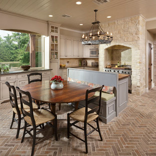 Inspiration pour une grande salle à manger ouverte sur la cuisine méditerranéenne avec un sol en brique, un mur beige et un sol marron.
