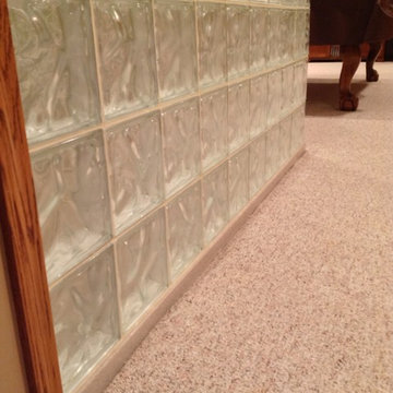Solid surface low threshold shower base and a glass block wall in a recreation r