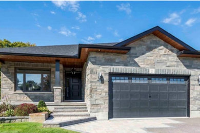 Trendy gray one-story stone and board and batten house exterior photo in Other with a shingle roof and a black roof