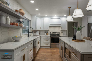 Eat-in kitchen - large transitional l-shaped porcelain tile and brown floor eat-in kitchen idea in Orlando with an undermount sink, shaker cabinets, quartzite countertops, beige backsplash, porcelain backsplash, stainless steel appliances, an island and white countertops