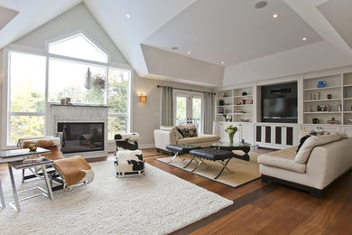Photo of a large contemporary open concept family room in Toronto with grey walls, dark hardwood floors, a standard fireplace, a stone fireplace surround, a wall-mounted tv and brown floor.
