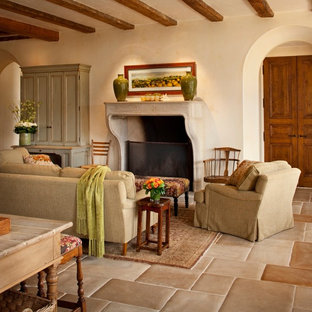 Modelo de salón abierto, mediterráneo, de tamaño medio, sin televisor, con paredes beige, chimenea tradicional, suelo de baldosas de cerámica y marco de chimenea de hormigón