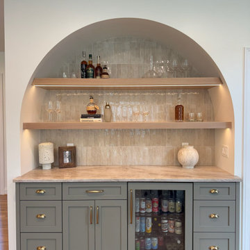 Frameless painted kitchen perimeter with rift cut oak islands and dry bar
