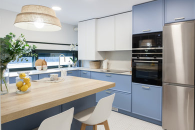 Enclosed kitchen - large contemporary l-shaped ceramic tile and white floor enclosed kitchen idea in Madrid with an undermount sink, raised-panel cabinets, white cabinets, quartz countertops, white backsplash, quartz backsplash, stainless steel appliances, a peninsula and white countertops