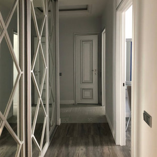 Inredning av en klassisk mellanstor hall, med grå väggar och laminatgolv
