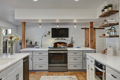 Mid-sized 1960s galley terra-cotta tile and red floor open concept kitchen photo in Phoenix with an undermount sink, shaker cabinets, white cabinets, quartzite countertops, multicolored backsplash, metal backsplash, stainless steel appliances, an island and white countertops
