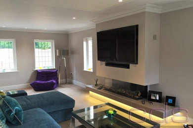 Immagine di un grande soggiorno minimal con pareti beige e TV a parete