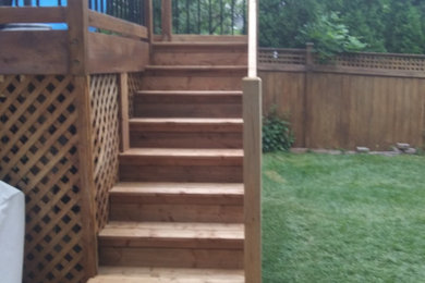 Deck - mid-sized traditional backyard ground level privacy and wood railing deck idea in Ottawa