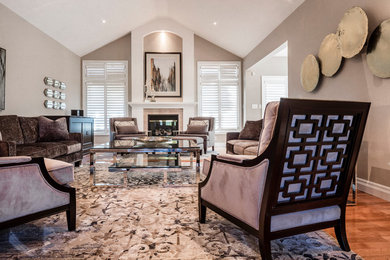 Inspiration for a large contemporary open concept medium tone wood floor living room remodel in Toronto with beige walls, a standard fireplace, a wood fireplace surround and a concealed tv