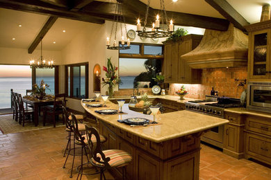 Example of a large l-shaped terra-cotta tile open concept kitchen design in Orange County with medium tone wood cabinets, granite countertops, terra-cotta backsplash, stainless steel appliances and an island