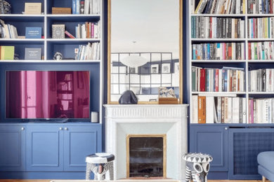 Réalisation d'un salon tradition de taille moyenne avec un mur bleu, parquet clair, une cheminée standard, un manteau de cheminée en pierre et un sol beige.